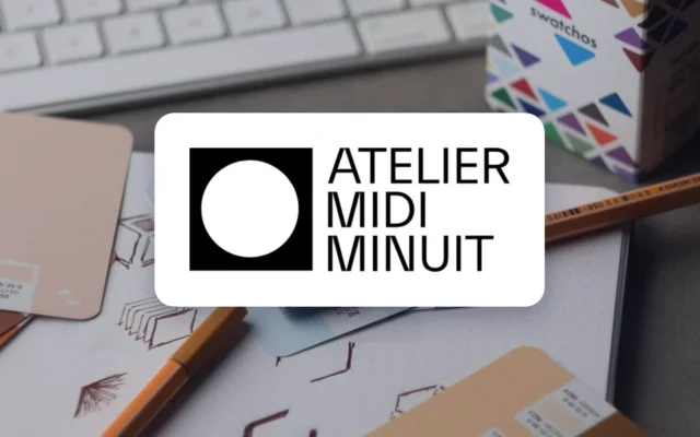 Logo de l’Atelier Midi Minuit sur un bureau de graphiste avec nuanciers et crayons